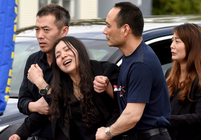 Peter Wang's mother, Hui, cries as she is helped into a waiting car with her family after the memorial service for her 15-year-old son at Kraeer Funeral Home in Coral Springs, Fla., Tuesday, Feb. 20, 2018. Peter Wang is a victim in the shooting at Marjory Stoneman Douglas High School.  (Taimy Alvarez/South Florida Sun-Sentinel via AP)