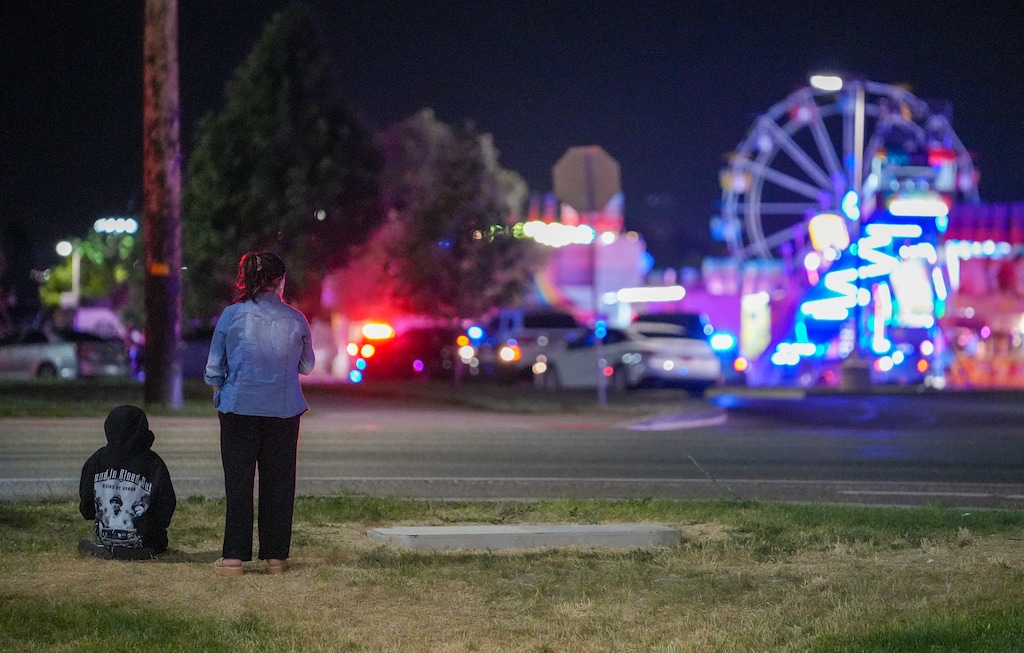 (Chris Samuels | The Salt Lake Tribune) Onlookers watch as law enforcement investigate after a shooting at WestFest in West Valley City, Sunday, June 15, 2025.