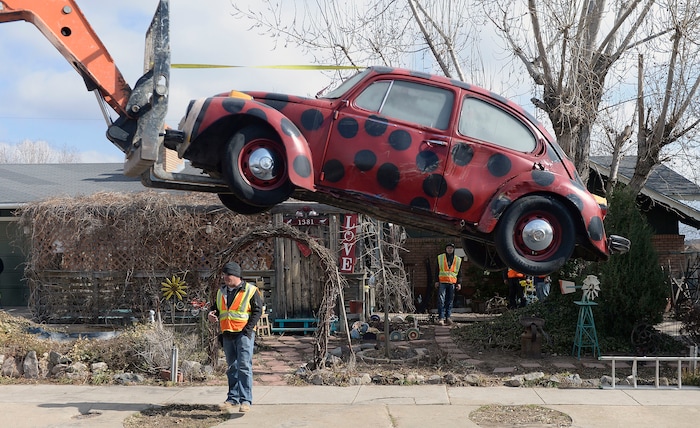 (Al Hartmann | The Salt Lake Tribune)
Clearfield public works personnel use a crane to remove Janis Zettel's gutted VW Beetle from a tree in her front yard Tuesday Feb. 13. She put it up a few months ago as an art installation. Now it has to come down. Bug is safely lowered to the ground after being removed from the tree.