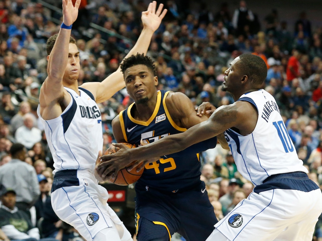 Dallas Mavericks forward Dwight Powell (7) and forward Dorian Finney-Smith (10) defend Utah Jazz guard Donovan Mitchell (45) during the second half of an NBA basketball game in Dallas, Wednesday, Nov. 14, 2018. Dallas won 118-68. (AP Photo/Michael Ainsworth)
