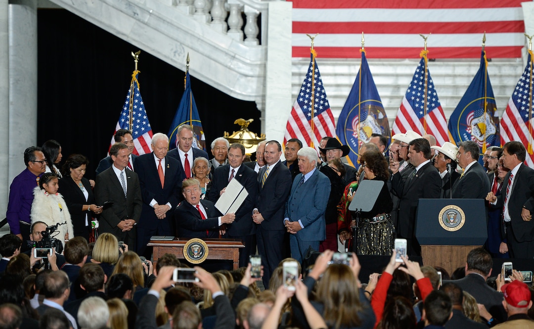 (Francisco Kjolseth  |  The Salt Lake Tribune)  U.S. President Donald Trump is surrounded by Utah representatives and many others at the Utah Capitol on Monday, Dec. 4, 2017, as he signs the presidential proclamation to shrink Bears Ears national monument.