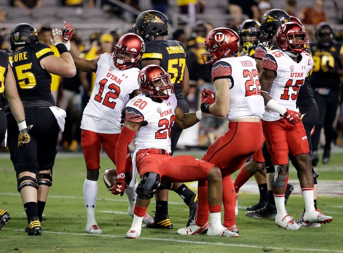 Utah defensive back Marcus Williams (20) celebrates his interception against Arizona State with teammate Justin Thomas (12) and Chase Hansen (22) during the first half of an NCAA college football game, Thursday, Nov. 10, 2016, in Tempe, Ariz. (AP Photo/Matt York)