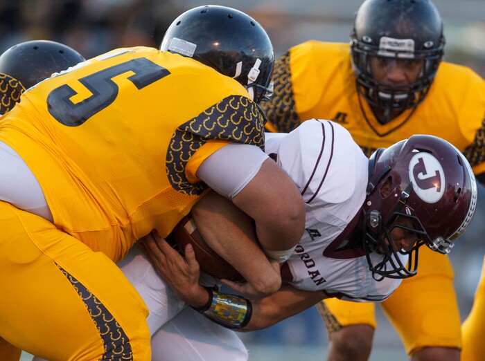 (Trent Nelson  |  The Salt Lake Tribune)  Jordan's Austin Kafentzis is brought down by Cottonwood's Villami Pulu as Cottonwood hosts Jordan High School football, Friday October 5, 2012 at Rice-Eccles Stadium in Salt Lake City, Utah.