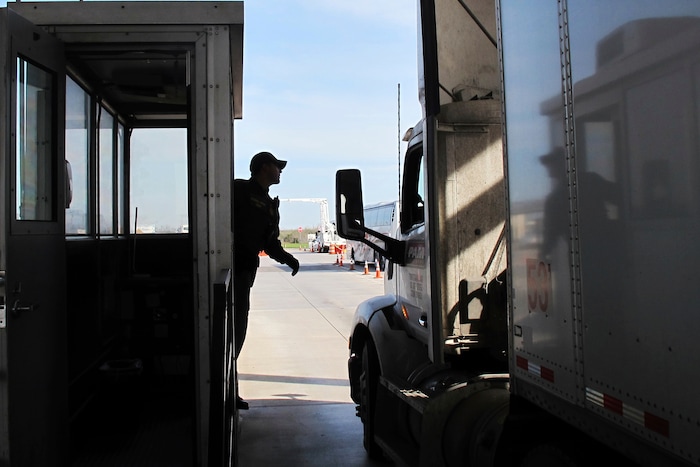 Border Patrol agent Eric Mendoza speaks to the driver of a tractor-trailer passing through the Laredo North vehicle checkpoint in Laredo, Texas, on Friday, Feb. 2, 2018. Smugglers routinely pack people entering the country illegally or drugs into tractor-trailers, counting on the vehicles not being opened at the inspection site. (AP Photo/Nomaan Merchant)