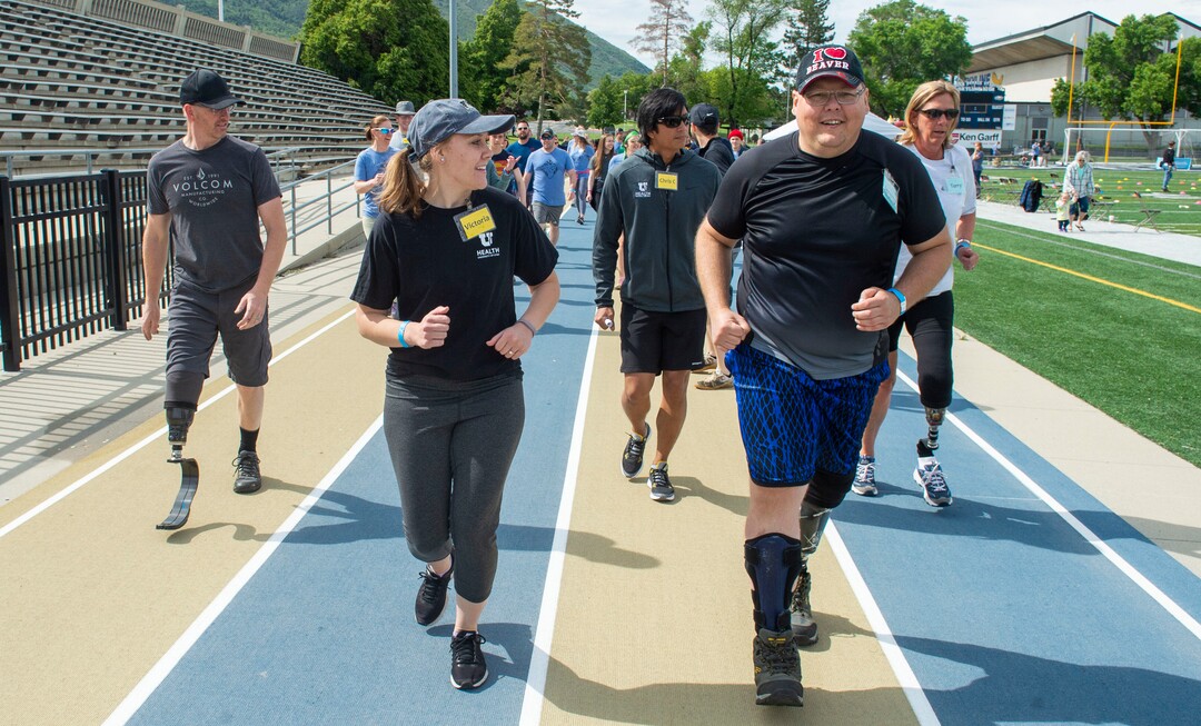 (Rick Egan  |  The Salt Lake Tribune)      Victoria Vega, from the University of Utah, runs with Jeremy Wayman from Kearns, during the fourth annual Utah Adaptive Mobility Clinic at Skyline High school. The clinic allows anyone with "lower extremity limb loss or limb difference" or amputees without legs, to practice walking and running. Saturday, June 1, 2019.