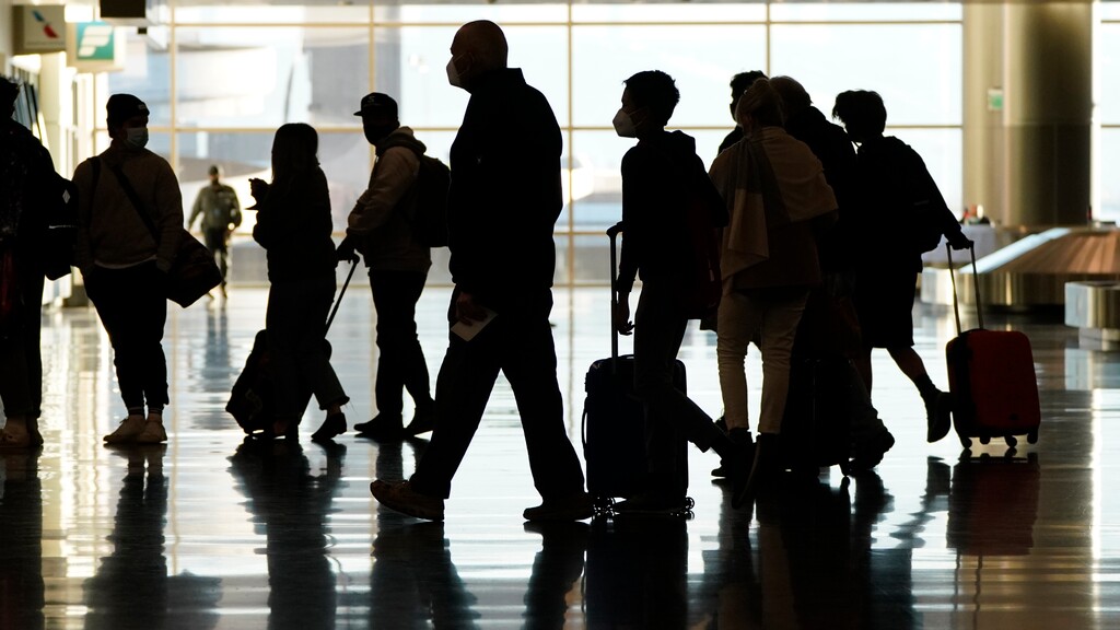 FILE - In this Nov. 25, 2020, file photo, air travelers line up to go through a a security checkpoint at Salt Lake City International Airport in Salt Lake City.