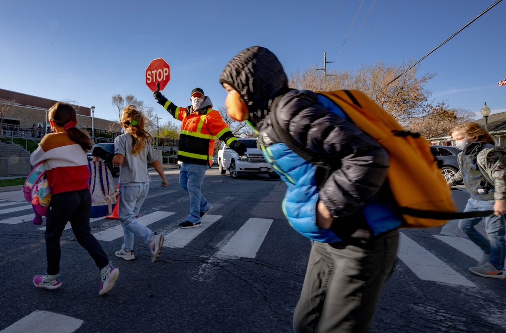 (Francisco Kjolseth | The Salt Lake Tribune) Students cross the street safely at Bonneville Elementary on Tuesday, April 20, 2021. Salt Lake City School District has now deferred to the mayor on whether to implement a mask mandate for kids during the 2021-2022 academic year.