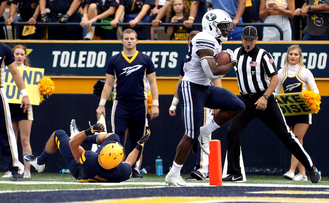 Toledo's Nate Bauer (6), left, fails to stop Brigham Young's Emmanuel Esukpa (33), right, from scoring a touchdown during a college football game between the University of Toledo and Brigham Young University at the Glass Bowl in Toledo, Ohio, on Saturday, Sept. 28, 2019. (Kurt Steiss/The Blade via AP)