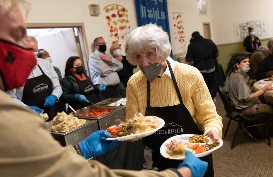 (Francisco Kjolseth | The Salt Lake Tribune) Pamela Atkinson helps hand out warm meals as The Rescue Mission of Salt Lake serves their annual Thanksgiving Banquet as part of their ongoing outreach to help the homeless on Monday, Nov. 22, 2021.