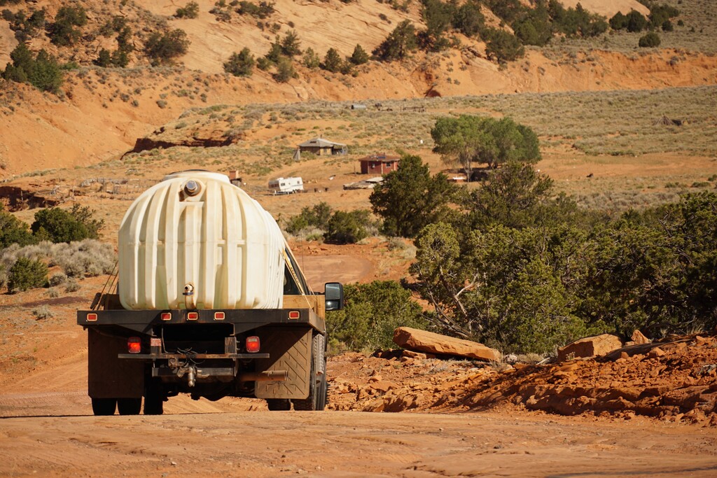 (Zak Podmore | The Salt Lake Tribune) Donovan Smallcanyon drives 1,200 gallons of water down a steep section of road to Piute Mesa in Utah on his water delivery route with the nonprofit DigDeep on July 1, 2020.                               
