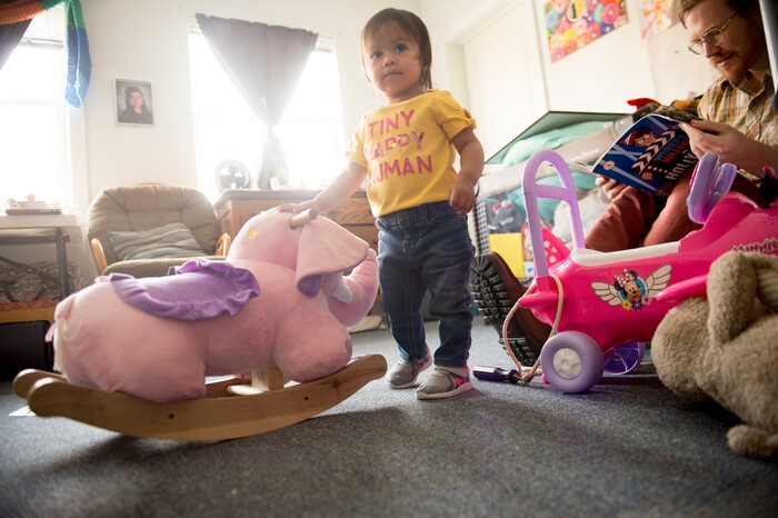 (Jeremy Harmon  |  The Salt Lake Tribune) Seventeen-month-old Bella plays with toys as volunteer Easton Smith looks at a book in the Chavez family room at the First Unitarian Church on 1300 East in Salt Lake City on Dec. 14, 2018.