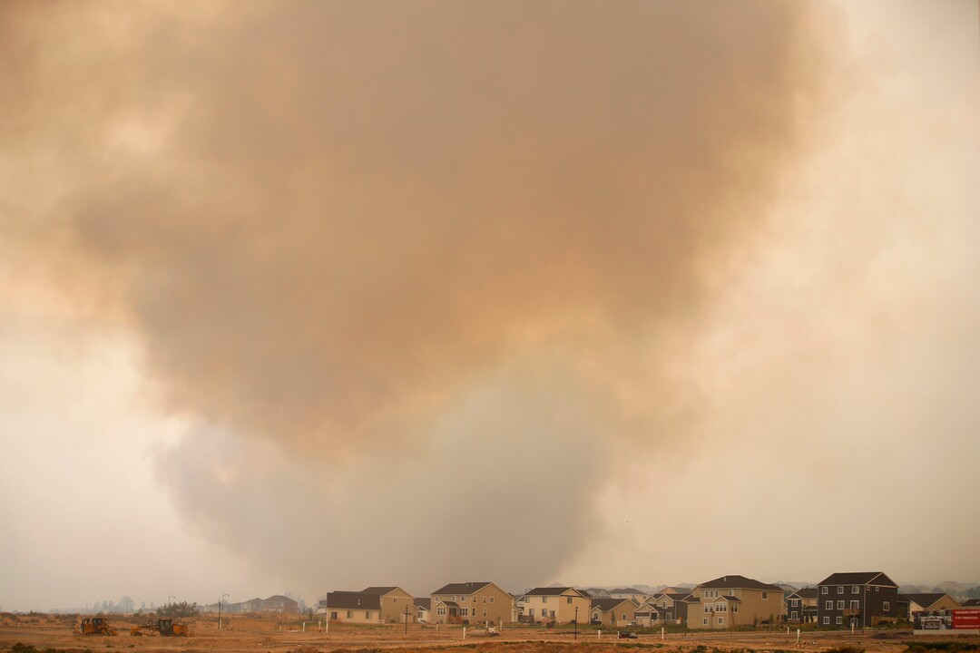 (George Frey  |  for The Salt Lake Tribune) Smoke from a wildfire rises above homes in south Saratoga Springs on June 28, 2020.