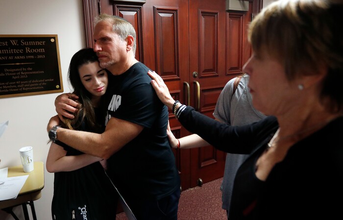 Rabbi Bradd Boxman of Congregation Kol Tikvah, hugs Aria Siccone, 14, a 9th grade student survivor from Marjory Stoneman Douglas High School  after they interrupted a legislative committee hearing to speak and challenge lawmakers on gun control legislation, at the state capitol in Tallahassee, Fla., Wednesday, Feb. 21, 2018. (AP Photo/Gerald Herbert)