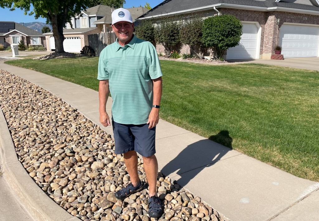 (Tim Vandenack | Standard-Examiner) Washington Terrace Mayor Mark Allen stands outside his home on Tuesday, July 12, 2022, in the park strip that he converted from grass to rocks.