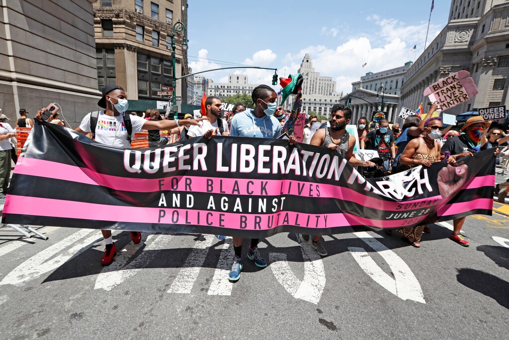 Participants in a queer liberation march for Black Lives Matter and against police brutality spread their banner across a street in Lower Manhattan, Sunday, June 28, 2020, in New York. (AP Photo/Kathy Willens)