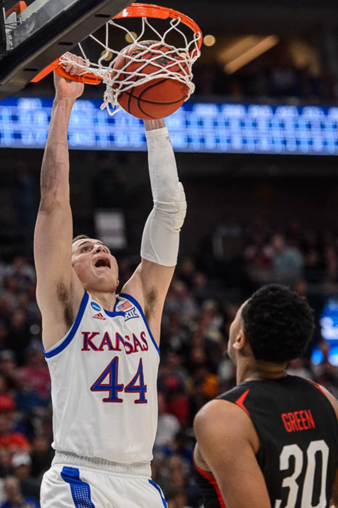 (Trent Nelson | The Salt Lake Tribune)  Kansas Jayhawks forward Mitch Lightfoot (44) dunks over Northeastern Huskies center Anthony Green (30) as Kansas faces Northeastern in the 2019 NCAA Tournament in Salt Lake City on Thursday March 21, 2019.