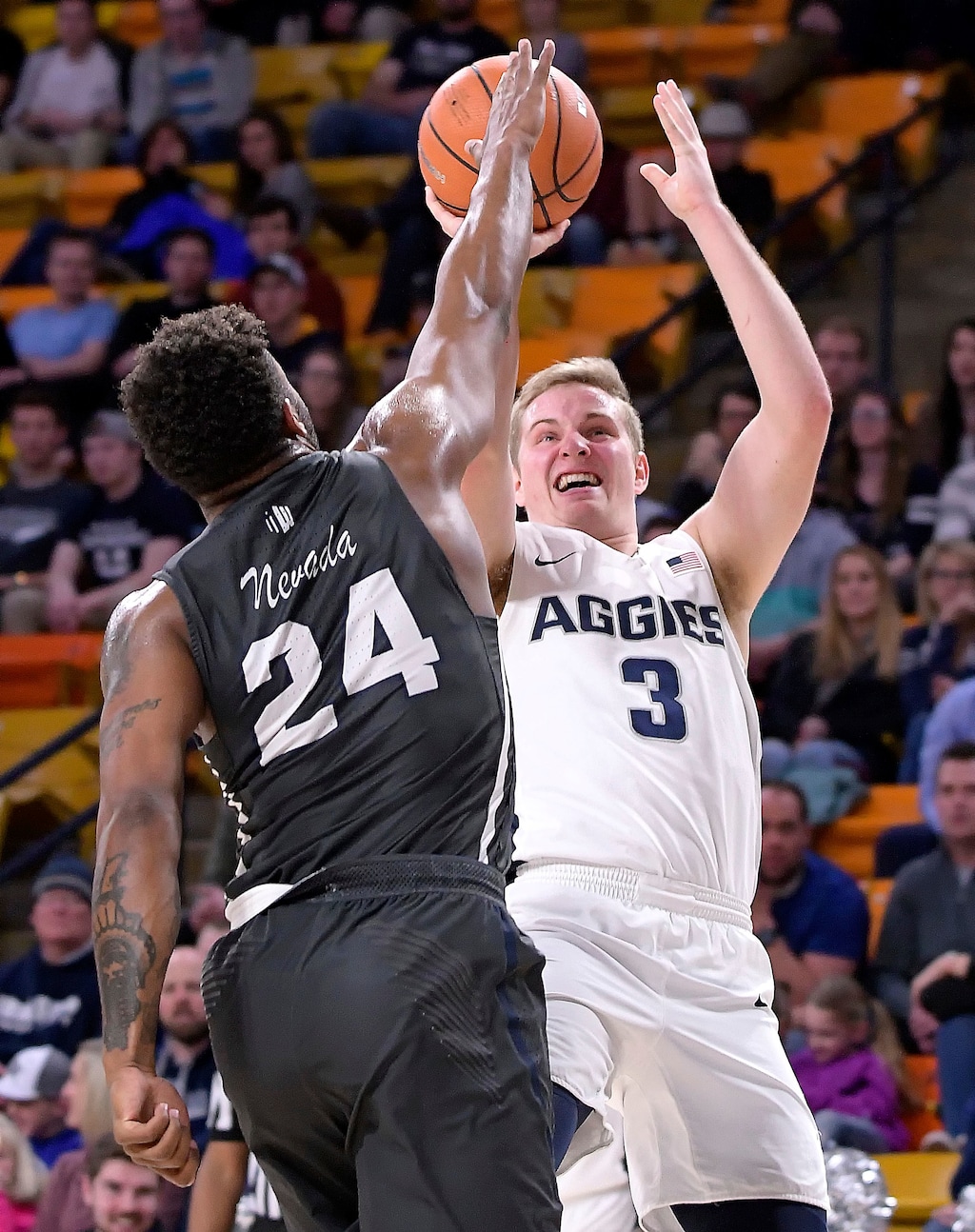 (Eli Lucero  |  The Herald Journal via AP)  Utah State guard Sam Merrill (3) shoots as Nevada guard Jordan Caroline (24) defends during an NCAA college basketball game Saturday, Feb. 17, 2018, in Logan, Utah.