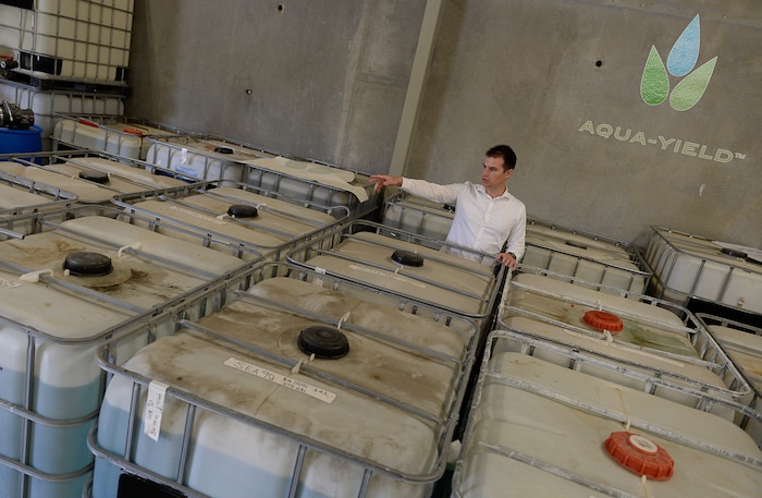 (Francisco Kjolseth  |  The Salt Lake Tribune)  Mike Bullock, president and cofounder of Aqua-Yield, a new company in Draper that uses nano technology to make fertilizers that it says are much more efficient for farmers to use, points out 275-gallon totes used to dilute its concentrated product. Aqua-Yeld can cut down the use of fertilizers by as much as 80 percent or more, the company says.
