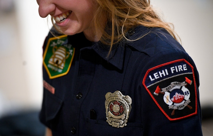 In this Jan. 19, 2018, photo, Lehi firefighter and paramedic Aubrey Freiberg laughs as she helps prepare dinner with fellow firefighters at Station 82 of the Lehi Fire Department in Lehi, Utah. (Isaac Hale/The Daily Herald via AP)