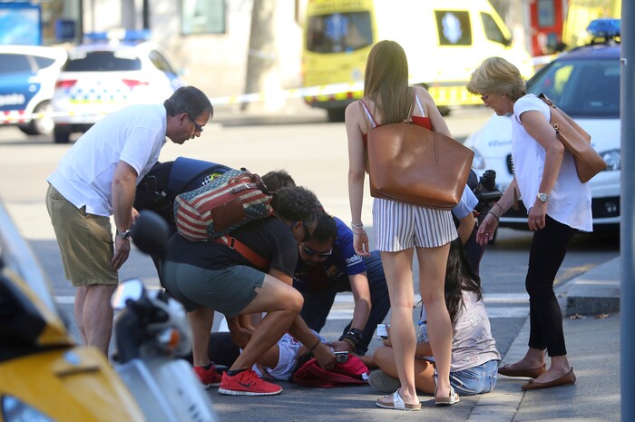 (Oriol Duran | The Associated Press) A person is treated in Barcelona, Spain, Thursday, Aug. 17, 2017 after a white van jumped the sidewalk in the historic Las Ramblas district, crashing into a summer crowd of residents and tourists and injuring several people, police said.