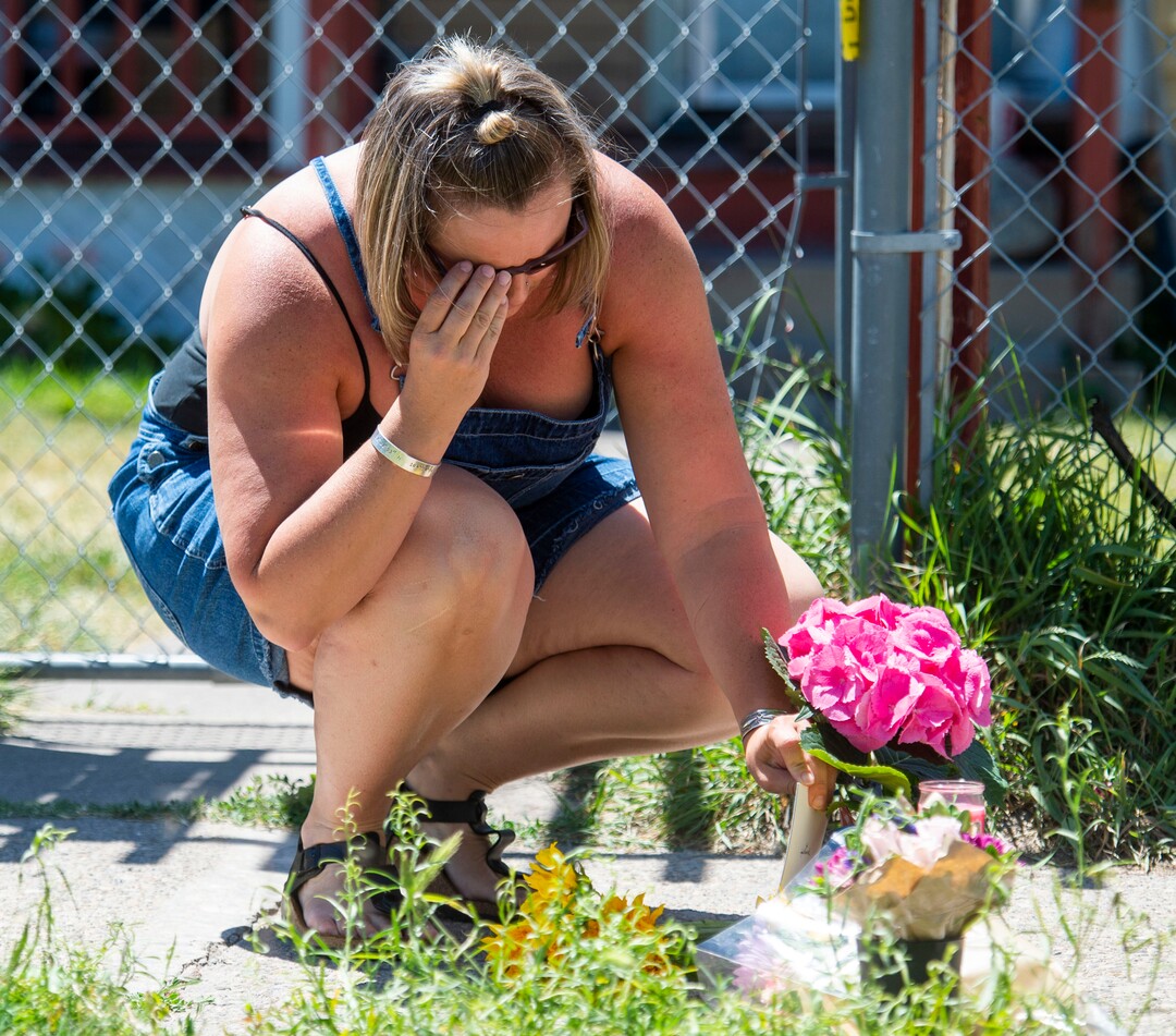 (Rick Egan  |  The Salt Lake Tribune)     Rose Park neighbor Thea Pirmann leaves some flowers at a memorial next to the Fairpark home on 1000 West, that the police have been searching, Friday, June 28, 2019.