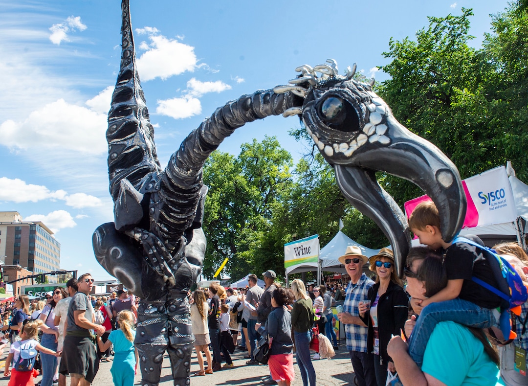 (Rick Egan  |  The Salt Lake Tribune)   The A Sauruse goes after one of the kits, as it  wanders the Utah Arts Festival, Saturday, June 22, 2019.