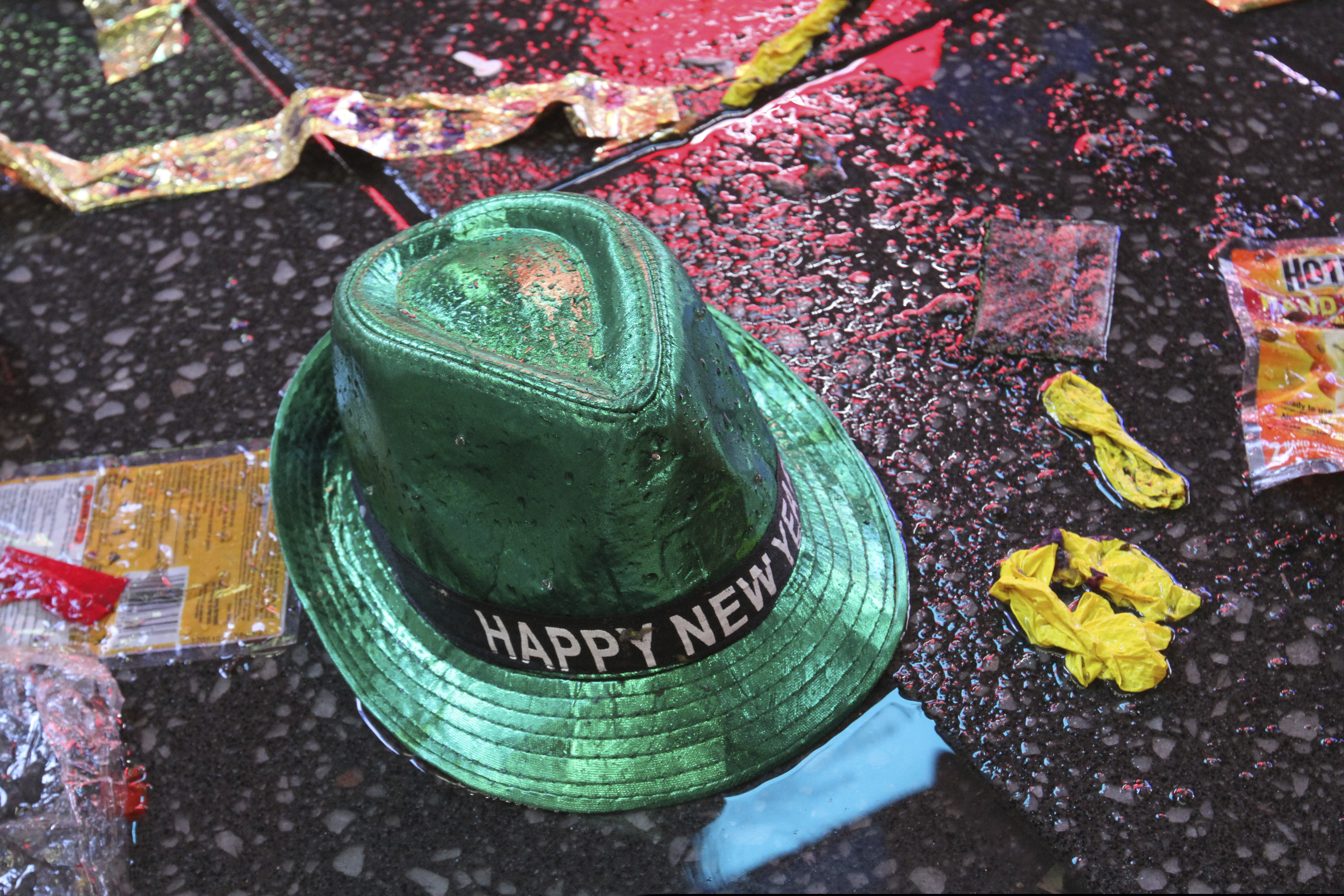 FILE - In this Jan. 1, 2019, file photo a "Happy New Year" hat lies on the wet ground along with other items following the celebration in New York's Times Square. Setting a New Year’s resolution about improving your finances is an excellent way to start 2021. But before you come up with a list of goals, be aware that there are a few you should avoid. (AP Photo/Tina Fineberg, File)