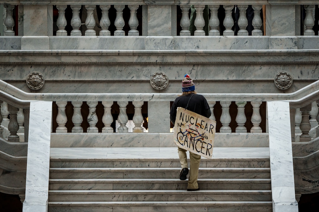 (Trent Nelson  |  The Salt Lake Tribune) A protestor carries a sign reading, "Nuclear Cancer" at the Utah Capitol in Salt Lake City on Tuesday, March 4, 2025.
