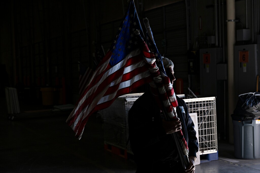 (Bridget Bennett | The New York Times)

An election worker carries American flags at the Clark County Election Department in North Las Vegas, Nev.. on Nov. 4, 2022.