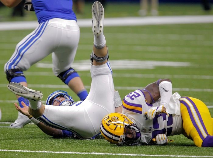 BYU quarterback Tanner Mangum (12) is sacked by LSU linebacker Corey Thompson (23) in the second half of an NCAA college football game in New Orleans, Saturday, Sept. 2, 2017. (AP Photo/Scott Threlkeld)