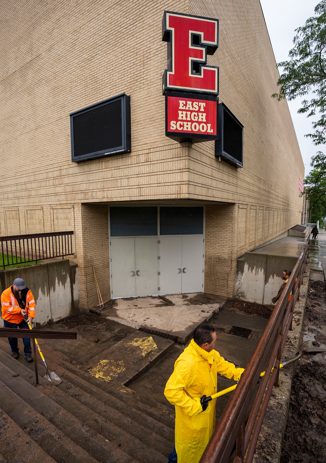 (Rick Egan | The Salt Lake Tribune) Workers clear mud and debris from the stairs leading to the gymnasium at East High School, on Monday, Aug. 2, 2021.