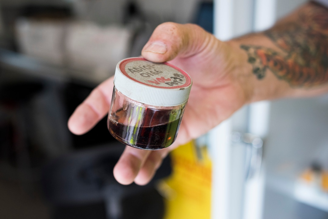 (Briana Scroggins  |  The Utah Investigative Journalism Project) EPA On-scene Coordinator Paul Peronard holds a sample of an unknown, flammable, non-halogenated, non-oxidizing liquid in a testing trailer outside of the Swift building in Ogden on Thursday, May 16, 2019. The EPA started site clean up on April 1 and plan to finish by August 2019.