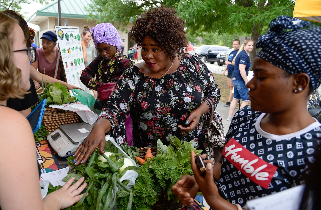 (Francisco Kjolseth  |  The Salt Lake Tribune)   Francine Nitgenga of Congo, center, and her daughter Nima Abakuki load up on fresh vegetables for their large family at the Sunnyvale Farmers Market at 4013 S. 700 West, which draws a weekly refugee clientele on Saturday, July 13, 2019, selling food grown exclusively by refugees living in Utah.