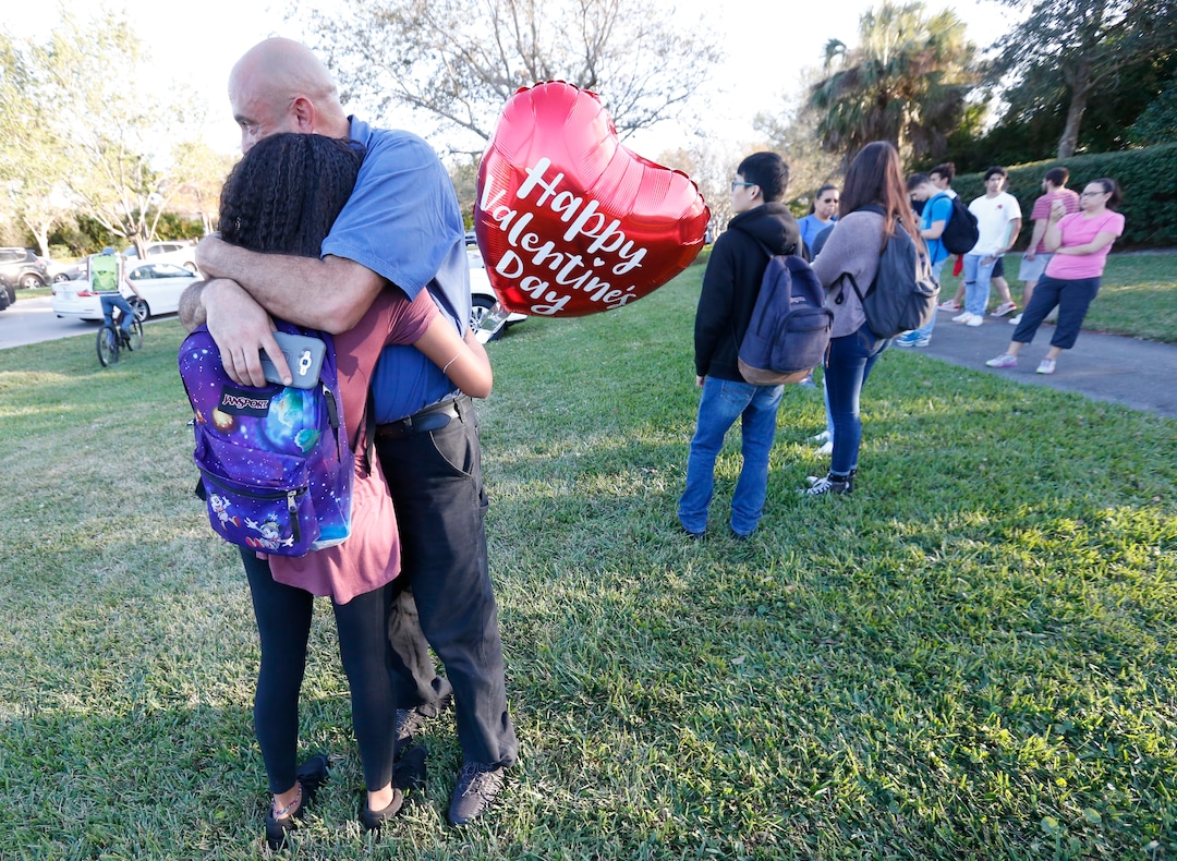 Family member embrace following a shooting at Marjory Stoneman Douglas High School, Wednesday, Feb. 14, 2018, in Parkland, Fla. (AP Photo/Wilfredo Lee)