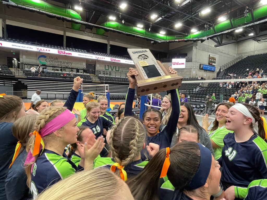 (Alex Vejar | The Salt Lake Tribune) Ridgeline junior setter Nia Damuni, center, holds the 4A volleyball trophy as she celebrates winning the school's first 4A championship on Thursday, Oct. 28, 2021, at the UCCU Center in Utah Valley University.