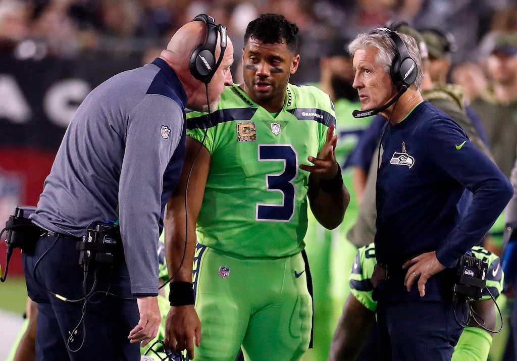 FILE - In this Thursday, Nov. 9, 2017, file photo, Seattle Seahawks quarterback Russell Wilson (3) speaks with head coach Pete Carroll, right, and assistant head coach Tom Cable during an NFL football game against the Arizona Cardinals in Glendale, Ariz. The Seahawks have been fined $100,000 for not properly following concussion protocol with Wilson during this game in November. The NFL and NFLPA announced their decision Thursday, Dec. 21, 2017, following an investigation that lasted more than a month.. (AP Photo/Rick Scuteri, File)