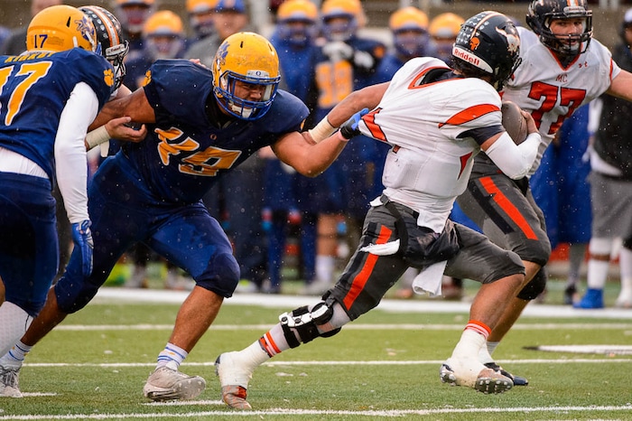 (Trent Nelson | The Salt Lake Tribune)  Orem's William Tenney (49) grabs Mountain Crest's Brady Hall (1) as Orem faces Mountain Crest in the Class 4A High School State Football Championship game in Salt Lake City, Friday November 17, 2017.