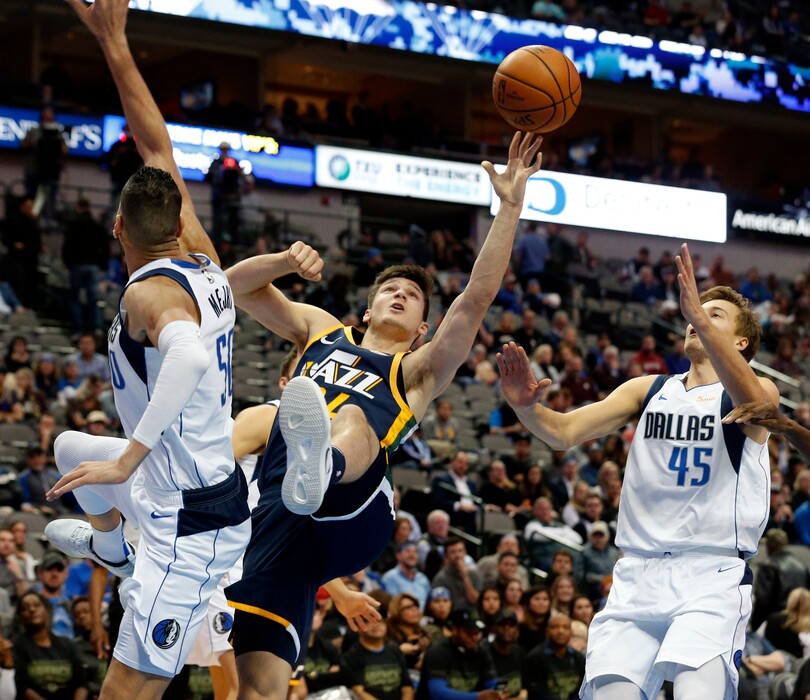Utah Jazz guard Grayson Allen (24) puts up a shot as he is defended by Dallas Mavericks center Salah Mejri (50) and guard Ryan Broekhoff (45) during the second half of an NBA basketball game in Dallas, Wednesday, Nov. 14, 2018. Dallas won 118-68. (AP Photo/Michael Ainsworth)