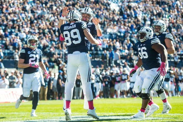 (Chris Detrick  |  The Salt Lake Tribune)  Brigham Young Cougars tight end Matt Bushman (89) celebrates with Brigham Young Cougars quarterback Tanner Mangum (12) after scoring a touchdown during the game at LaVell Edwards Stadium Saturday, October 28, 2017.  