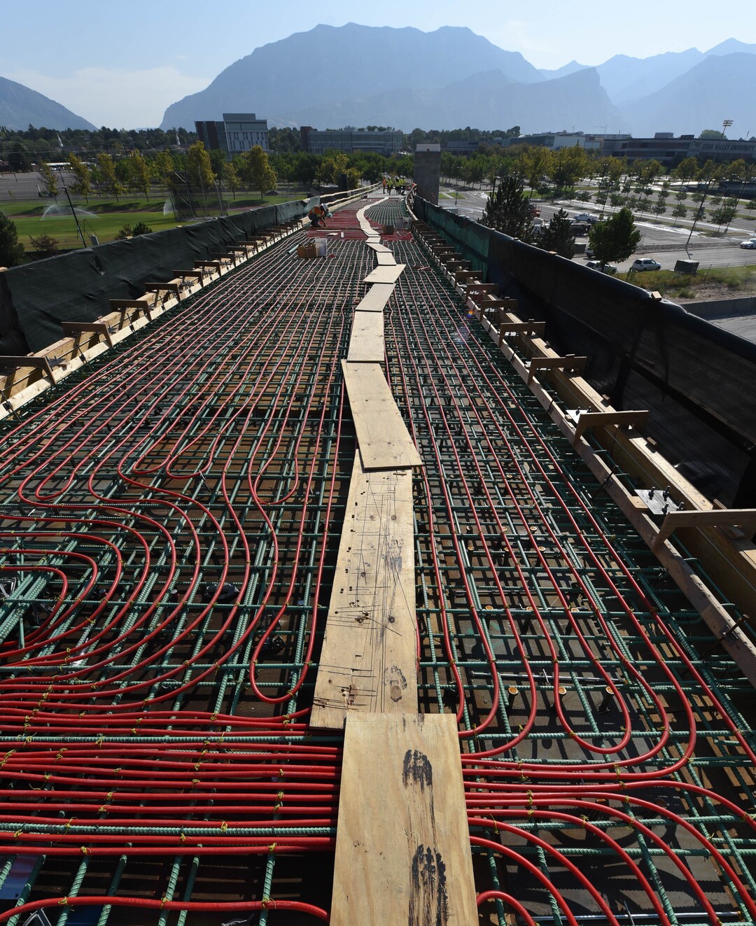 (Francisco Kjolseth  |  The Salt Lake Tribune) UDOT gives a tour of the state’s new longest pedestrian bridge on Thursday, August 20, 2020, connecting Utah Valley University in Orem to student housing and the community on the West side of I-15. Crews are finishing up an extensive hydronic heating system that will pump warm water to keep the bridge clear of snow in the winters, as it gets ready to pour concrete for the walking surface. UDOT will close I-15 in both directions this weekend for work on the nearly 1,000 foot bridge that is 15 feet wide to accommodate pedestrians, cyclists and scooters. Elevators and stairs with small ramps to push up bicycles will be on each side of the bridge.