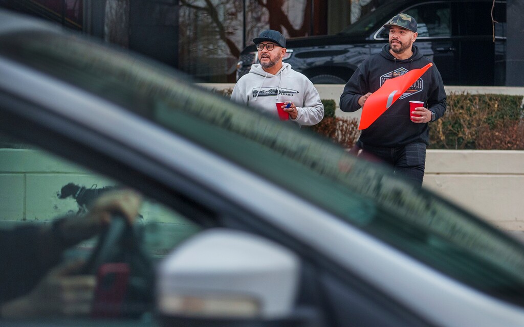 (Leah Hogsten | The Salt Lake Tribune) "It's a little hairy," said James Campos, left, of dodging traffic while crossing 255 S. West Temple at the pedestrian crosswalk with his colleague Gabriel Valdivia on Friday, February 3, 2023. Salt Lake City is reinvesting in the longstanding, bright orange crosswalk flags, but some question how effective they are.