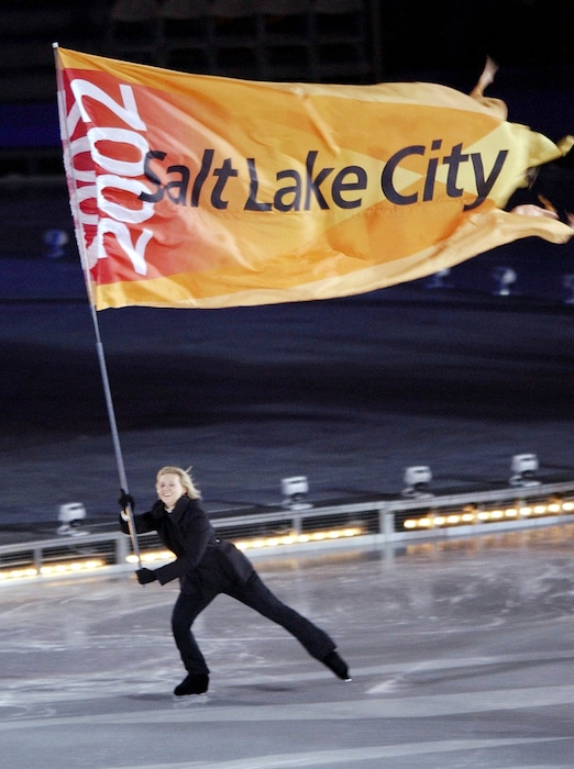 (Kevork Djansezian  |  Associated Press file photo) In this Feb. 8, 2002, photo, a Salt Lake City Olympic flag is skated into the Rice-Eccles Olympic stadium during the opening ceremonies of the 2002 Winter Olympics in Salt Lake City.