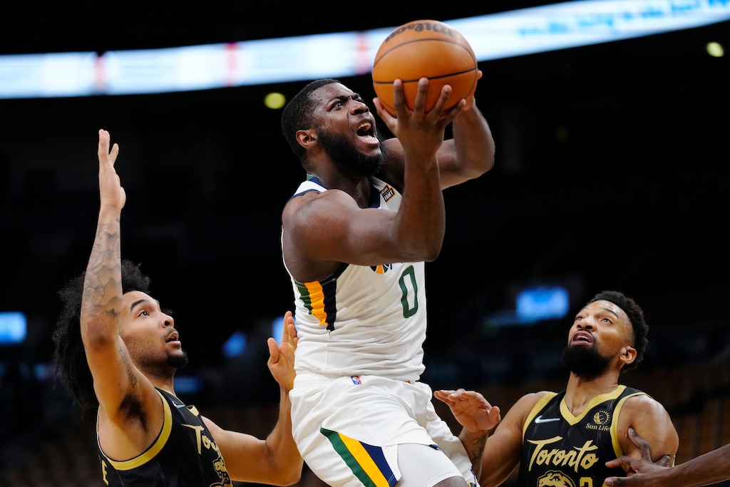 Utah Jazz forward Eric Paschall (0) prepares to shoot from between Toronto Raptors forward Justin Champagnie, left, and center Khem Birch during the first half of an NBA basketball game Friday, Jan. 7, 2022, in Toronto. (Frank Gunn/The Canadian Press via AP)