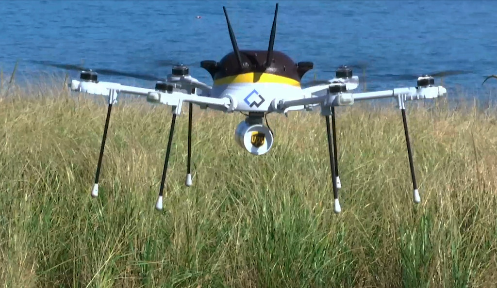 In this Thursday, Sept. 22, 2016 still image from video, a test drone making a UPS delivery lands on Children's Island in Marblehead, Mass. UPS partnered with robot-maker CyPhy Works to fly the drone on a programmed route for three miles over the Atlantic Ocean to make the delivery. (AP Photo/Rodrique Ngowi)