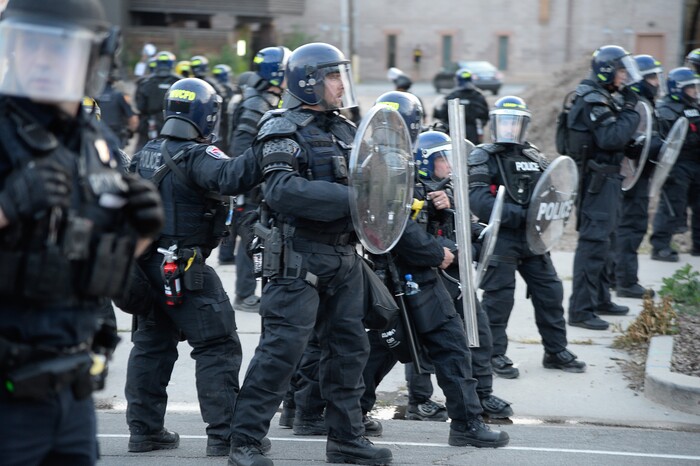 (Francisco Kjolseth  |  The Salt Lake Tribune) Police push forward along 300 East near the downtown library as they enforce a mandatory curfew in Salt Lake City on Monday, June 1, 2020, following violence and unrest over the weekend due to the death of George Floyd by police.