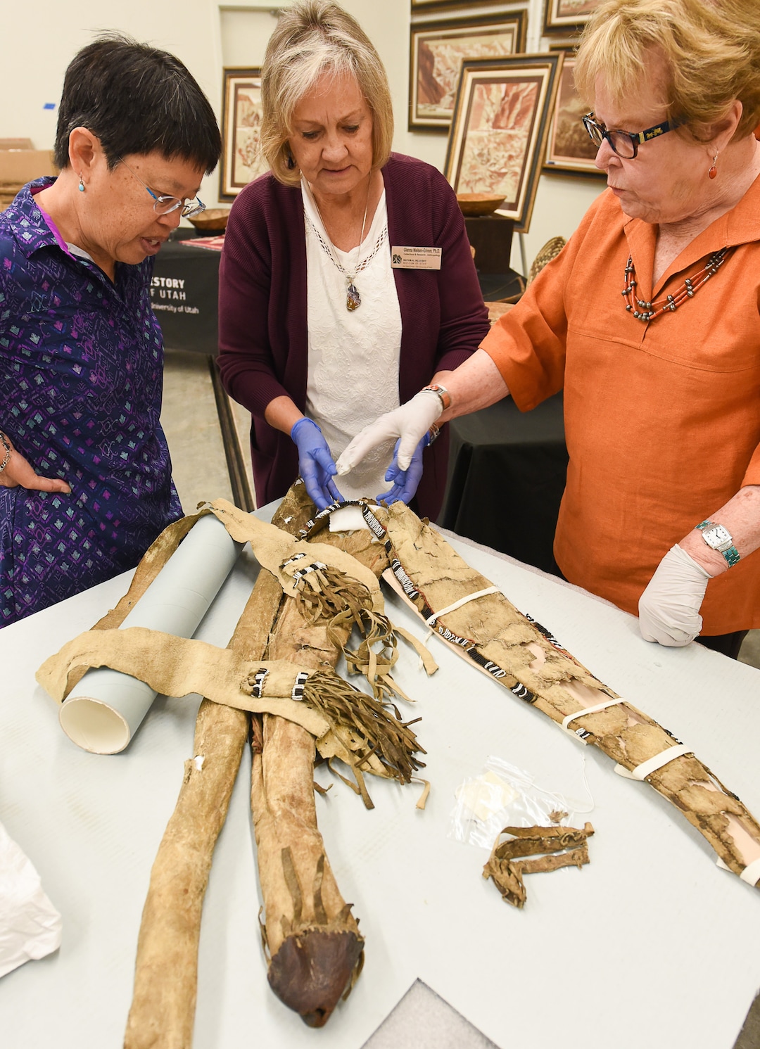 (Francisco Kjolseth  |  The Salt Lake Tribune)  University of Utah Geology and Geophysics Professor Marjorie Chan, Glenna Nielsen-Grimm, an anthropologist with collections and research at the Natural History Museum of Utah and anthropologist Catherine Sweeney Fowler from the University of Nevada, Reno, from left, inspect Ute tribe bow and quiver that was collected by John Wesley Powell, well known in Utah for his famed Colorado River expeditions in1869 and during 1871-1872. The artifacts will be displayed during a public event at the museum Saturday, Sept. 22, for one day only due to the delicate nature of the items.