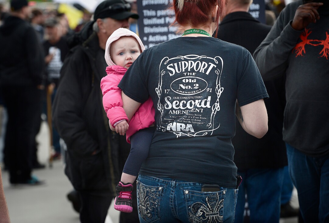 Scott Sommerdorf | The Salt Lake Tribune
A woman with a pro-NRA shirt held a baby as pro-gun March Before Our Lives marchers rallied across the street from West High School, Saturday, March 24, 2018.