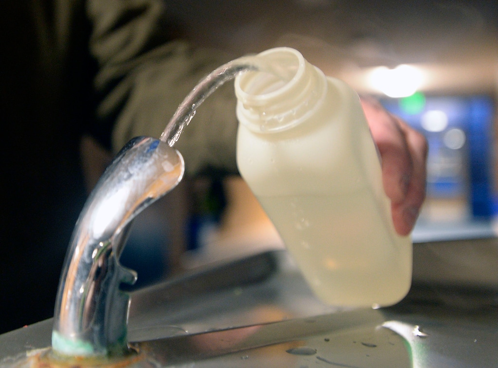 (Al Hartmann  | Tribune file photo) A school official taking water samples from a hallway drinking fountain in early 2016. An orange residue had been discovered on the school's toilets, prompting the school to test for contamination from metals such as iron, copper and lead in the drinking water. In 2017 state officials asked several Utah school districts to conduct voluntary lead tests. A high incidence of elevated lead levels in those initial samples has prompted state officials to urge testing at all schools statewide.