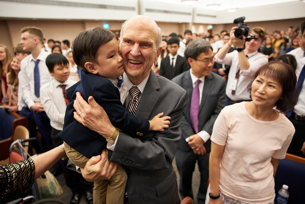 (The Church of Jesus Christ of Latter-day Saints)
Three-year-old Tate Chan gives church President Russell M. Nelson a hug after a devotional in Singapore in 2019. Tate's grandmother, Sarah Chan, right, watches. Tribune columnist Gordon Monson credits Nelson's call for peacemaking.