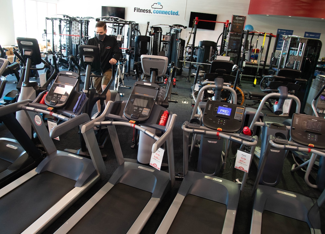 (Francisco Kjolseth  |  The Salt Lake Tribune) Chase Buckles, sales manager at Utah Home Fitness in Sandy, discusses popular exercise equipment on Wednesday, Oct. 22, 2020. Home fitness equipment sales boomed in March and April when gyms closed because of the coronavirus. Everything from inexpensive dumbbells to premium treadmills and ellipticals were wiped out of stores and warehouses. Record sales continue throughout the summer — normally the slow time for the industry, and store owners expect sales to remain high during the holidays.